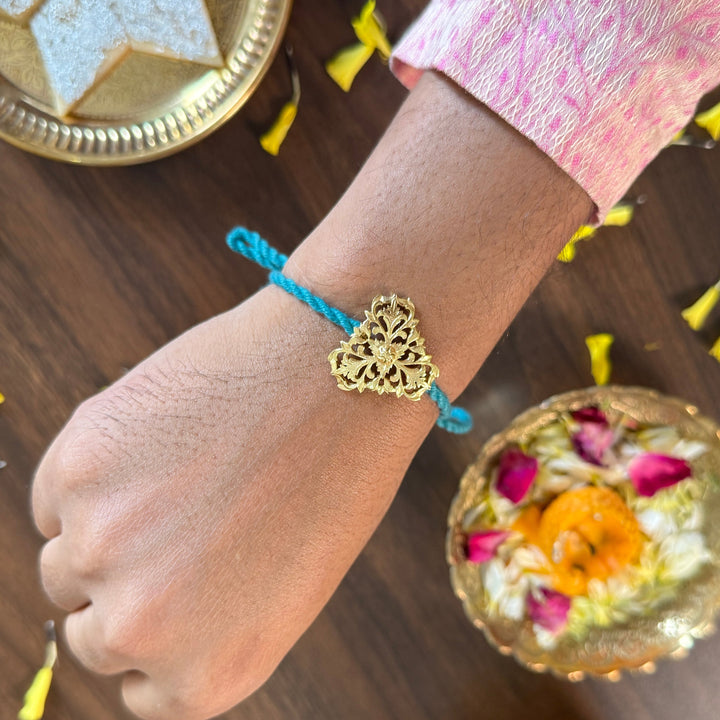 Hand wearing a blue bracelet with a gold heart charm on a festive table setting.